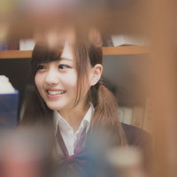本棚越しに見つめる女子高生の青春ポートレートの写真