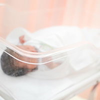 新生児室で検査を受ける赤ちゃんの医療風景の写真