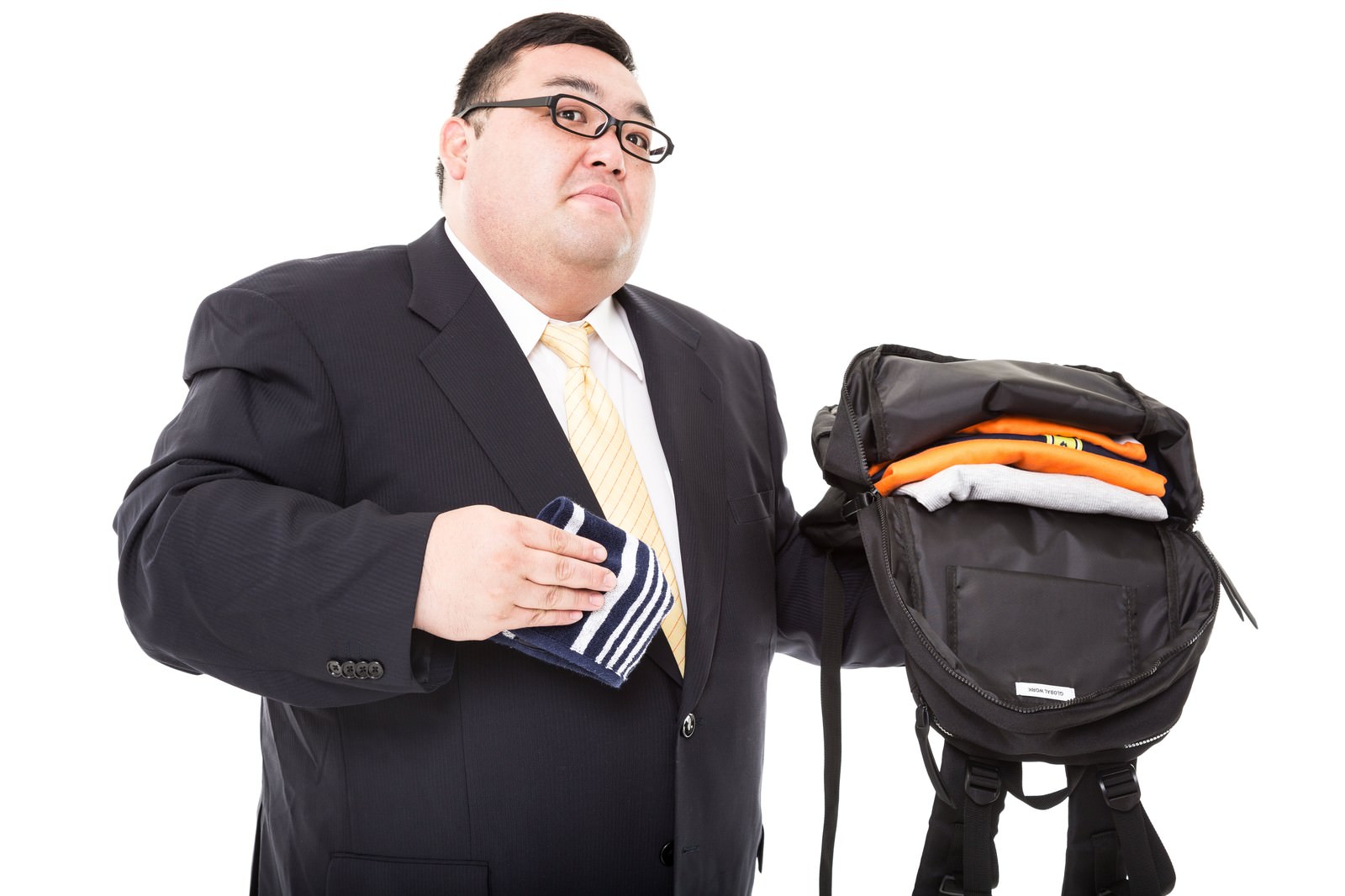 スーツ姿でバッグから着替えを取り出すメタボ体型の男性［モデル：横山ともや］