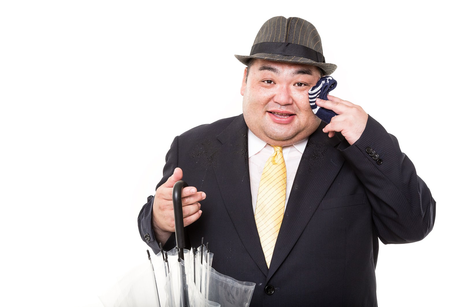 スーツの男性が傘を持ち電話しながら指をさしている［モデル：横山ともや］