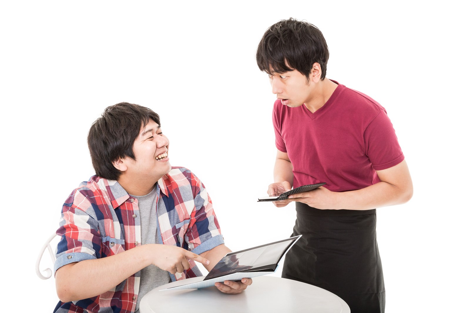 ピンク色のシャツを着た店員が、チェック柄シャツの男性客の注文をメモしている様子［モデル：あまのじゃく 大川竜弥］