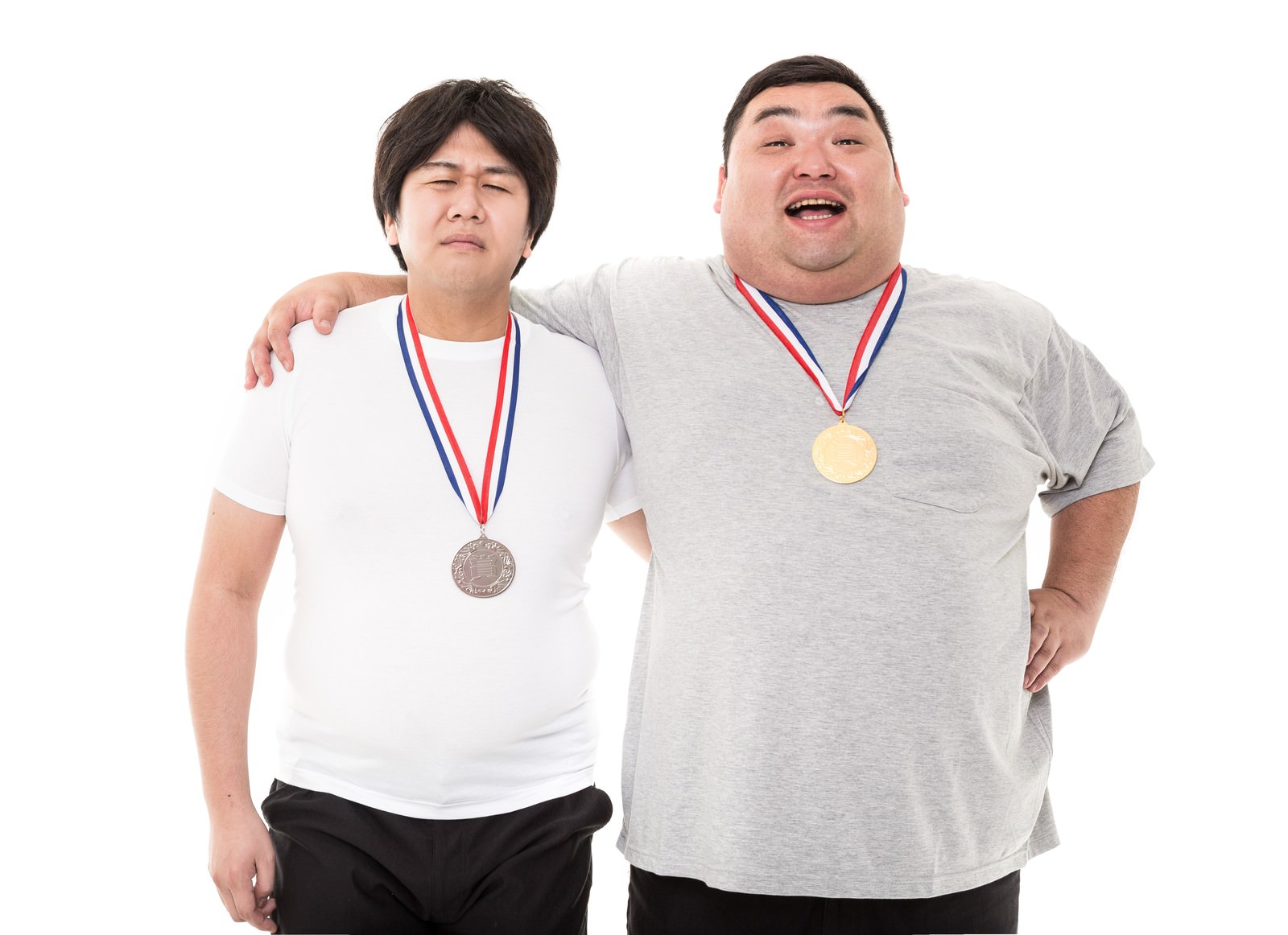 メダルを掲げて肩を組む男性二人［モデル：あまのじゃく 横山ともや］