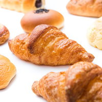 焼きたてクロワッサンと焼き菓子が並ぶパン祭りの販売風景の写真