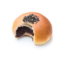 黒ごまをトッピングした食べかけのあんぱんの写真