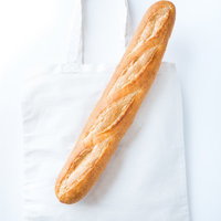 白いトートバッグに入ったフランスパンの写真