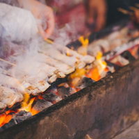 炭火で焼く屋台の焼き鳥、黄赤い炎と焼き色の写真