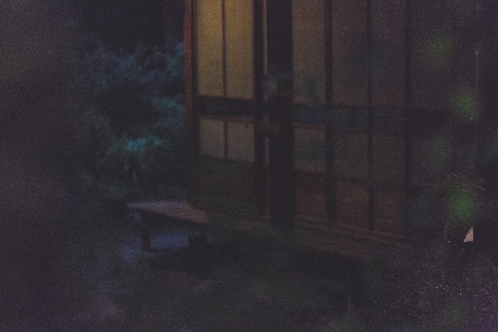 夜の古い建物の窓から明かりが漏れる外観