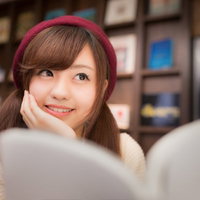 マンガを読みながら続きを妄想する美少女の笑顔の写真