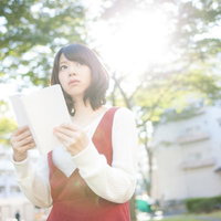 お散歩中に本を読む女性の写真