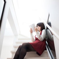 階段で漫画を読む美女、タブレットを持ち読書する日常風景の写真