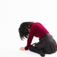 完膚なきまでに敗北した女性が床に膝をついてうなだれるの写真