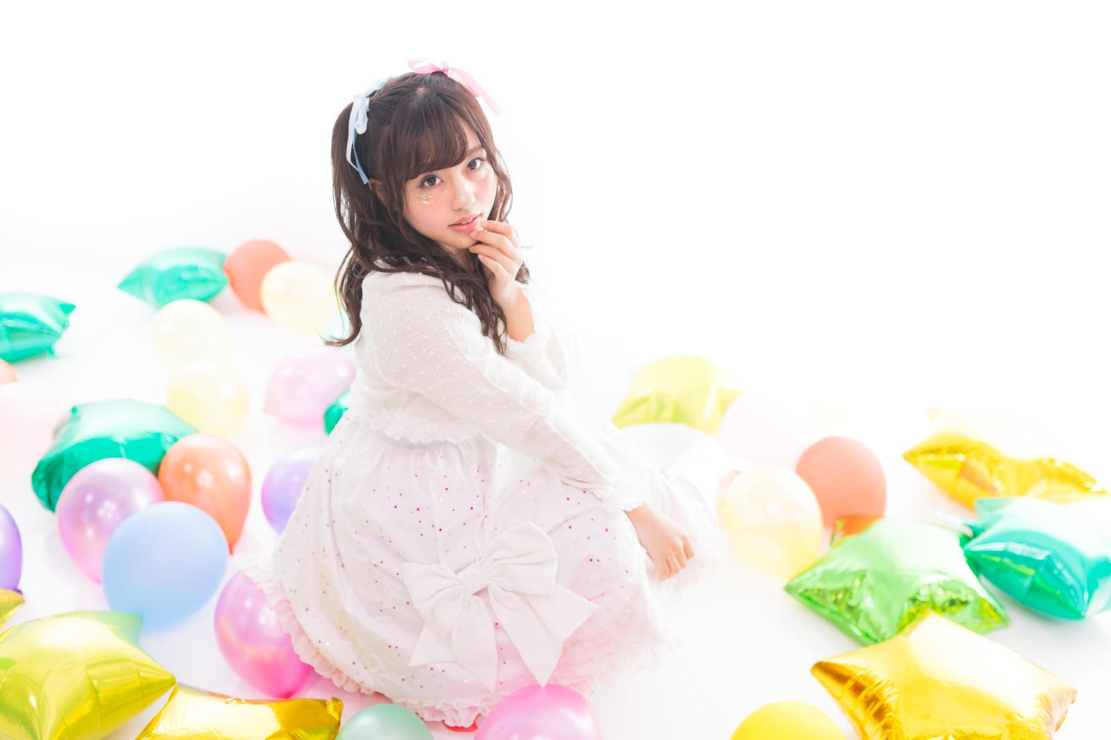 白いドレスを着た女性アイドルが振り返り斜め上を見上げている様子［モデル：河村友歌］