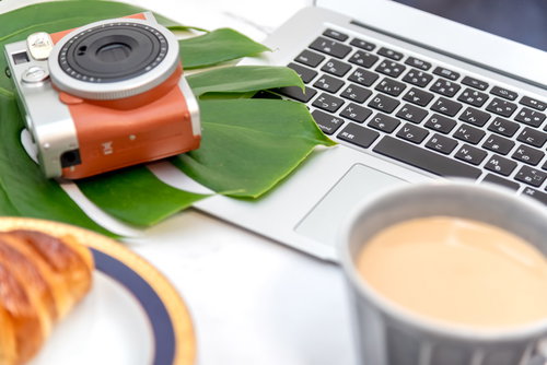 ノートパソコンのキーボードとインスタントカメラチェキ
