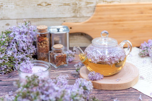 木製テーブルに溢れるライラックとティーポット
