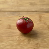 まな板の上に取り残された一個の赤いミニトマトの写真