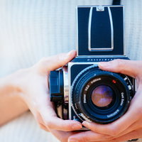 ハッセルブラッドのフィルムカメラを持った女性の手の写真
