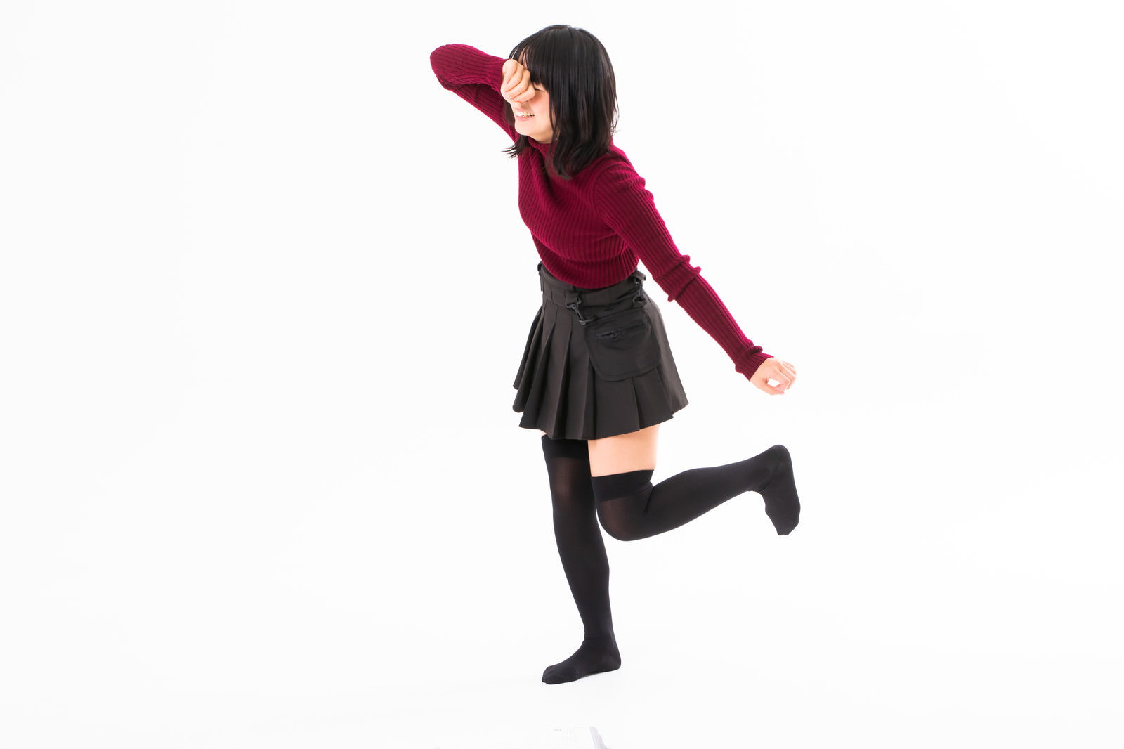 赤いトップスを着た女性が泣きながら走り去る様子［モデル：にゃるる］