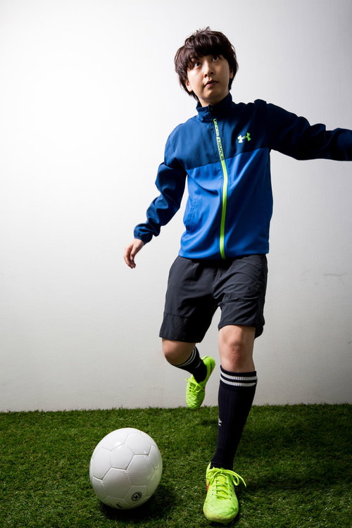 青いユニフォームの女子がサッカーボールをキック