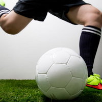 フリーキックの瞬間を捉えたサッカー選手のボールを蹴る動作の写真