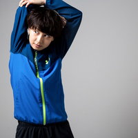 青いジャージで軽いストレッチをする女性の準備運動の写真