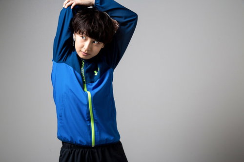 青いジャージで軽いストレッチをする女性の準備運動