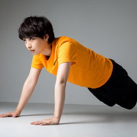 オレンジシャツで腕立て伏せをするスポーツ女子の写真