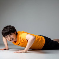 床で腕立て伏せをして苦しい表情の女性のフィットネスの写真