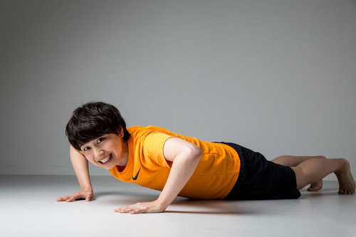 床で腕立て伏せをして苦しい表情の女性のフィットネス