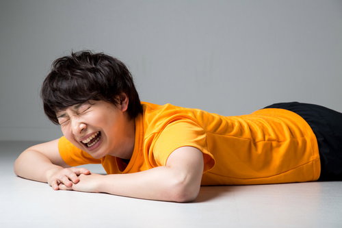 トレーニングに疲れて机に肘をついてヘトヘトな女性