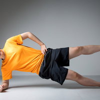 笑顔でサイドプランクするトレーニング男性インストラクターの写真