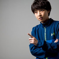 青いスポーツジャージ姿で指導するトレーナー女性の写真