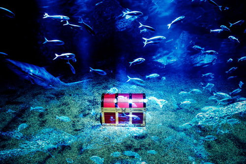 海底に眠る伝説の秘宝を囲む魚群が輝く冒険ファンタジー