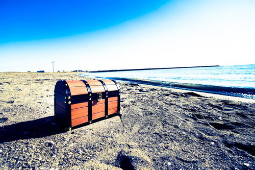 オレンジ色の宝箱が置かれた海岸線の砂浜と防波堤