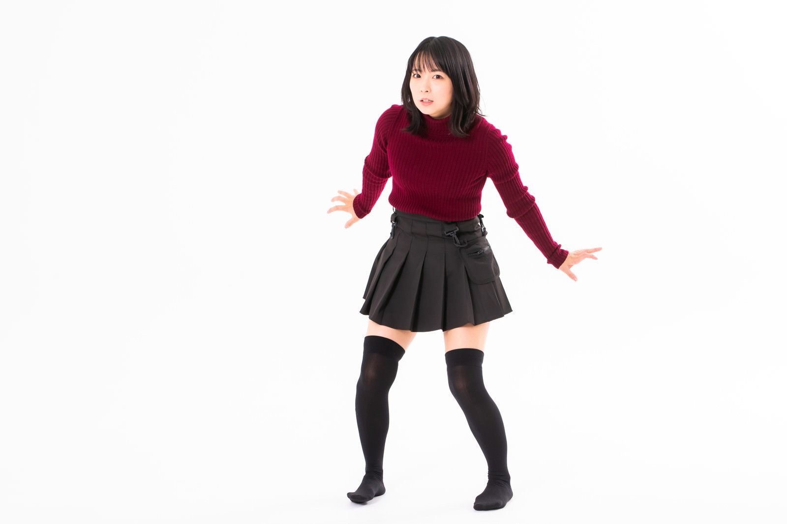 A woman in a red top and gray skirt is shrinking away, startled by something