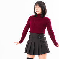 驚いて腰が引ける赤いニット姿の女性のポーズの写真