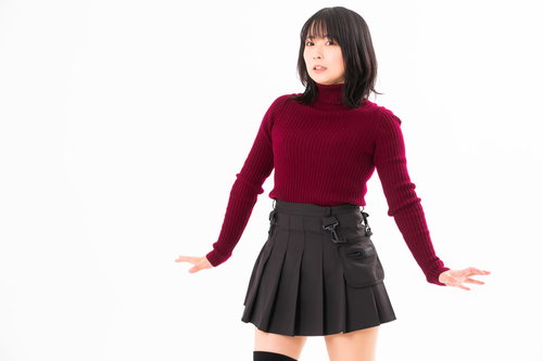 驚いて腰が引ける赤いニット姿の女性のポーズ