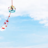 青空に吊るされた夏の風鈴の写真