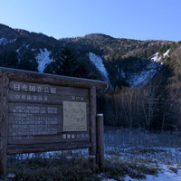 冬の日光白根山登山口に立つ木製の案内看板の写真