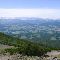 羊蹄山の山肌から眺める支笏湖の広大な盆地景観の写真
