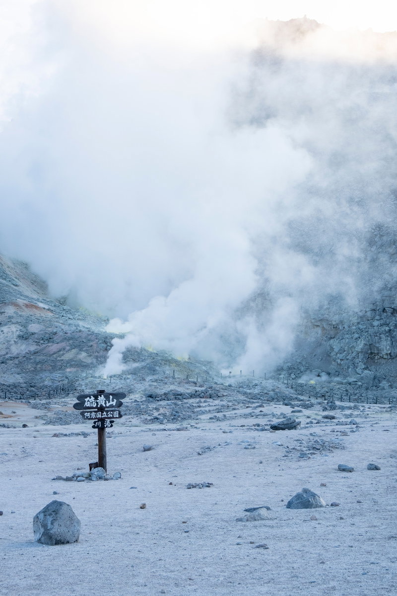 北海道硫黄山の荒涼とした火山地帯で白い噴煙が立ち上る風景