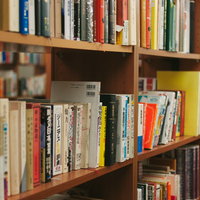 図書室の木製本棚に並ぶ多数の書籍と学習環境の写真