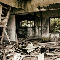 床が大きく抜けてボロボロに崩壊した廃アパートの室内の写真