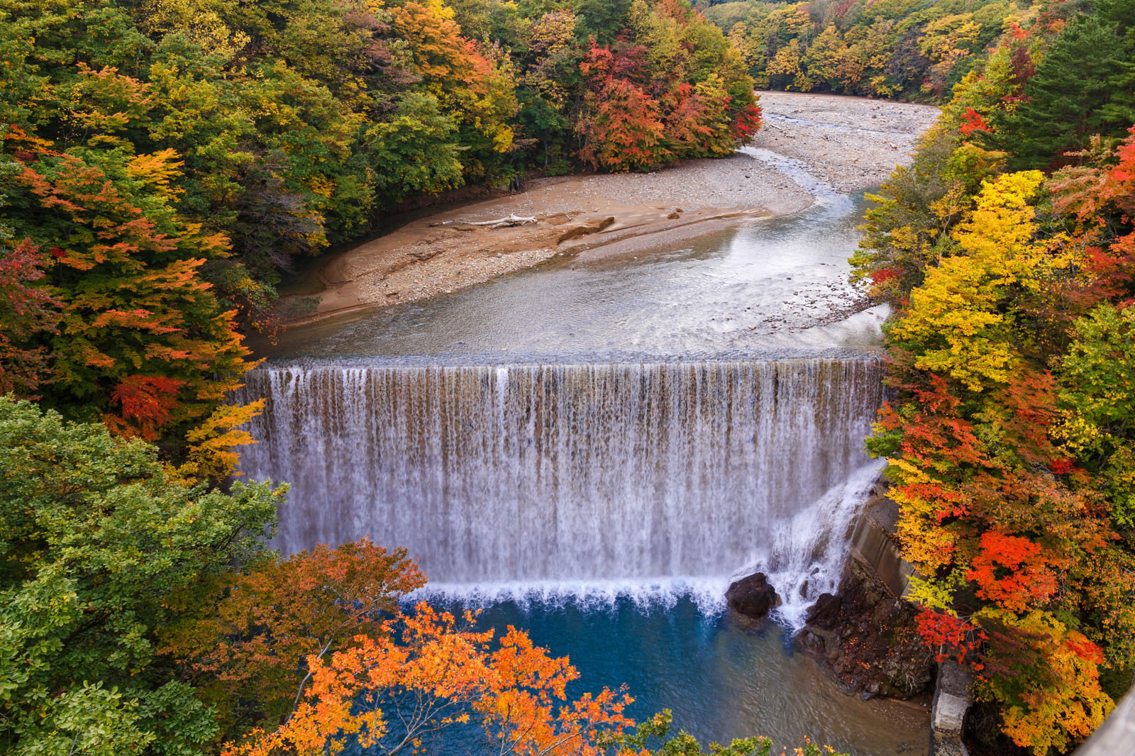 八幡平の紅葉に囲まれた滝と川の風景