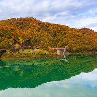 玉川ダム湖に映る秋の紅葉と黄葉、山々の彩りの写真
