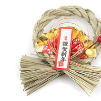 わらで編まれたしめ縄に赤い房飾りと謹賀新年の札の写真