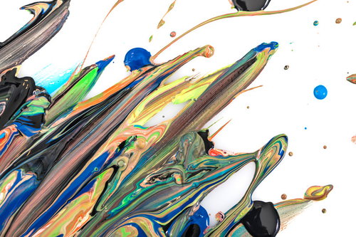 青や緑、黄色が流れるように混ざりあった絵の具