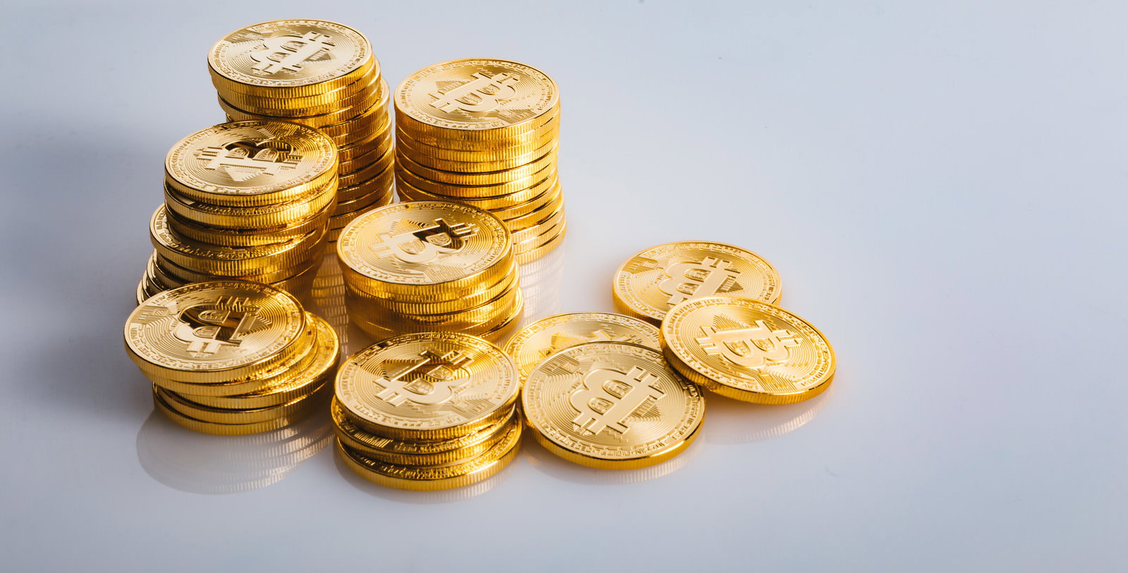 ビットコインのロゴが刻印された金色のコインが複数重なっている