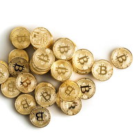 白い背景に散らばるビットコインのコイン - 暗号資産投資の写真