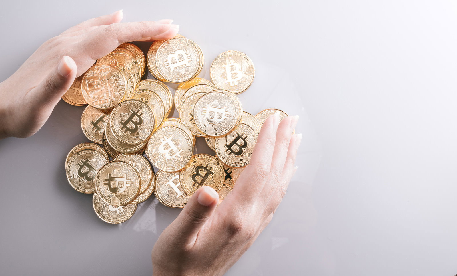 山積みのビットコインを両手で包む