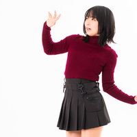 恐怖におののきながら両手を上げて後ずさりする女性の写真